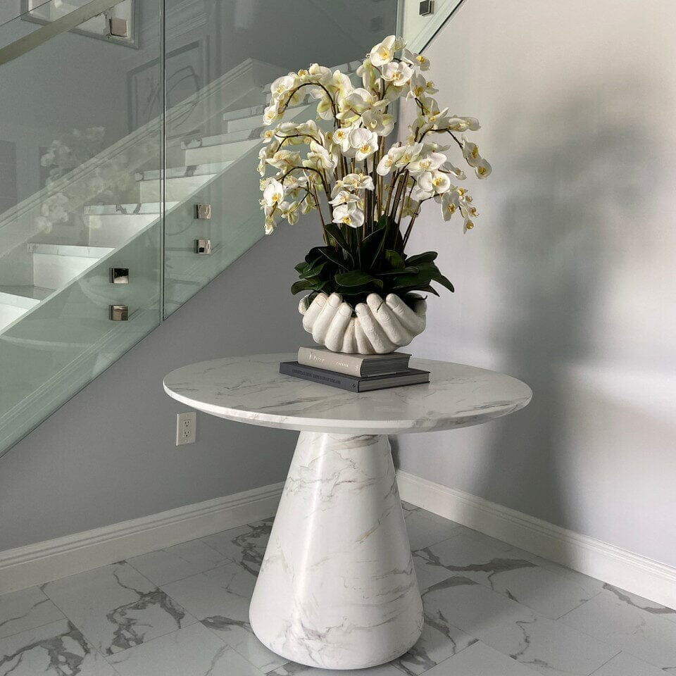 Orquídeas Phalaenopsis blancas en jarrón con la escultura «Manos abiertas»