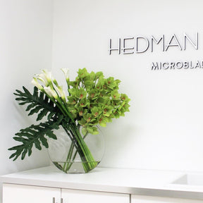 Jarrón lunar con cymbidiums verdes y calas