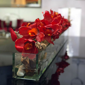 Jarrón de cristal moderno con cymbidiums rojos